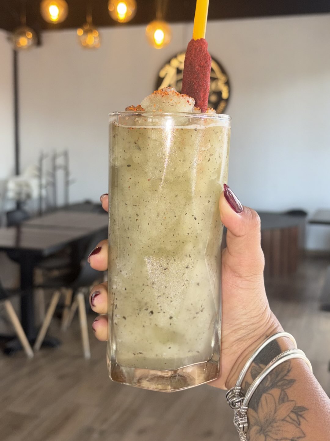 Granizado verde en vaso alto, interior de Amargo El Café al fondo