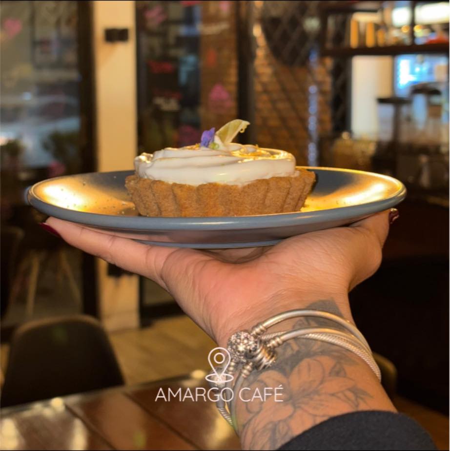 Postre artesanal en plato dorado, interior cálido de Amargo El Café